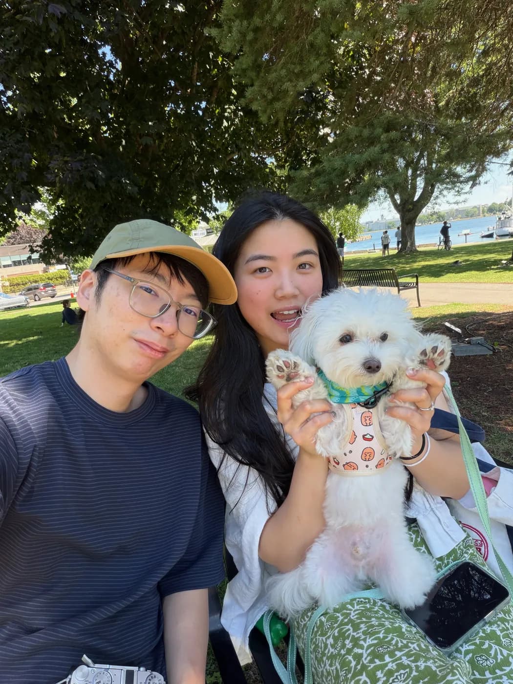 Felix and Livia in a lakeside park holding a small white dog